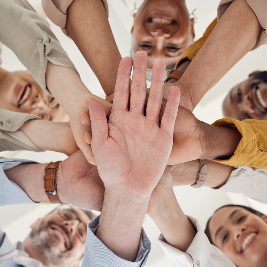 group of co-workers with hands in